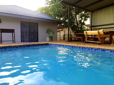 a swimming pool with blue water in front of a house at SnL 38 Hoep Hoep in Malelane