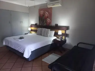 a bedroom with a large white bed with two lamps at SnL 38 Hoep Hoep in Malelane
