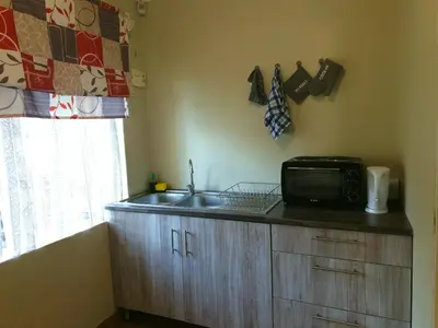 a kitchen with a sink and a microwave on a counter at SnL 38 Hoep Hoep in Malelane