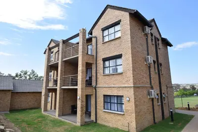 a large brick building with a balcony at Kyalami Creek in Midrand