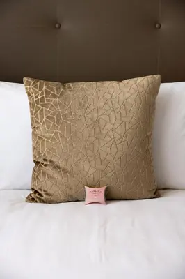 a pink price tag on a bed with a pillow at Kyalami Creek in Midrand
