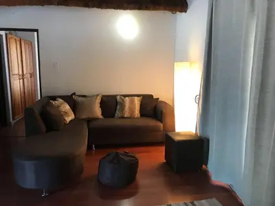 a living room with a brown couch and a table at Mopani Manor in Marloth Park