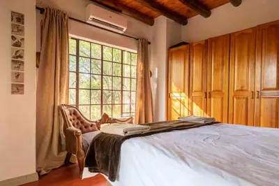 a bedroom with a bed and a large window at Mopani Manor in Marloth Park