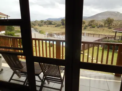 a view from the balcony of a house with two chairs at Riverview Inn in Malelane