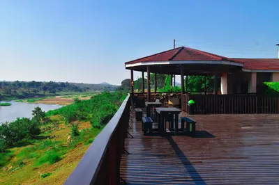 a boardwalk with a gazebo next to a river at Riverview Inn in Malelane