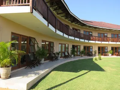 a building with chairs and a lawn in front of it at Riverview Inn in Malelane