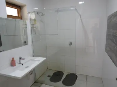 a white bathroom with a sink and a shower at Riverview Inn in Malelane