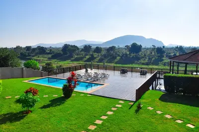 a resort with a swimming pool and mountains in the background at Riverview Inn in Malelane