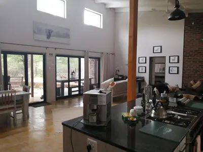 a living room with a kitchen and a living room with a table at Flight of the Eagle @ Kruger in Marloth Park