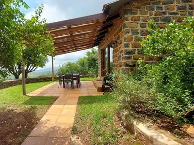 a patio with a table and a stone building at Marks Cottage in Dullstroom