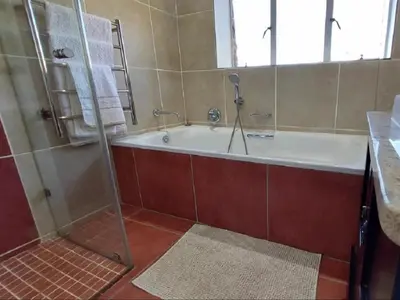 a bathroom with a bath tub and a shower at Marks Cottage in Dullstroom