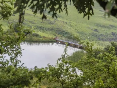 a train on a bridge over a body of water at Marks Cottage in Dullstroom
