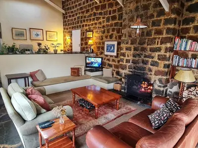 a living room with a couch and a fireplace at Marks Cottage in Dullstroom