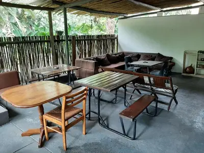 a living room with tables and a couch at Elephant Walk Guesthouse and Back Packers in Phalaborwa