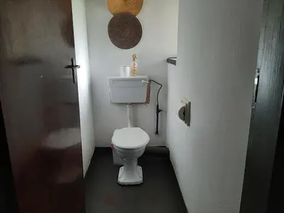 a small bathroom with a toilet in a room at Elephant Walk Guesthouse and Back Packers in Phalaborwa