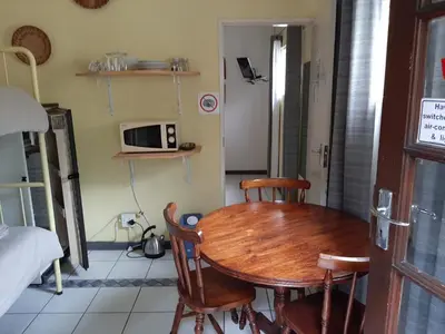 a kitchen with a table and chairs and a microwave at Elephant Walk Guesthouse and Back Packers in Phalaborwa