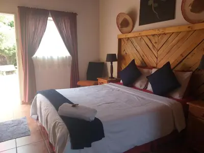 a bedroom with a large bed with a wooden headboard at The Clifton Room's in Centurion