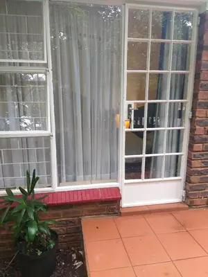 a window with white curtains and a potted plant at The Clifton Room's in Centurion