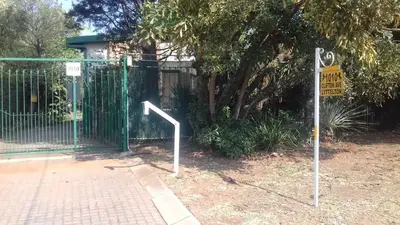 a gate with a sign in front of a fence at The Clifton Room's in Centurion