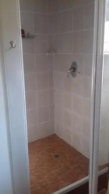 a bathroom with a shower with a tile floor at The Clifton Room's in Centurion