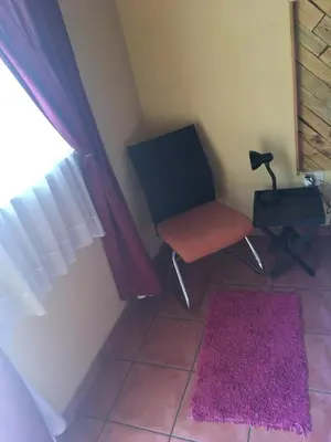 a room with a chair and a window and a rug at The Clifton Room's in Centurion