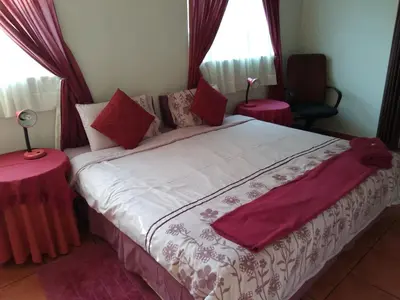 a bedroom with a large bed with two tables at The Clifton Room's in Centurion