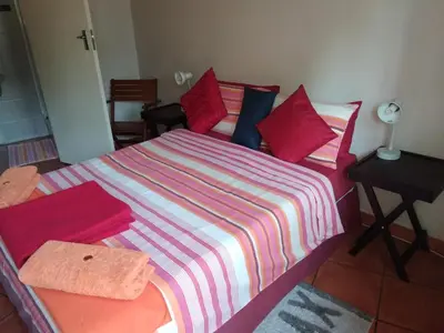 a bedroom with a bed with a striped blanket at The Clifton Room's in Centurion