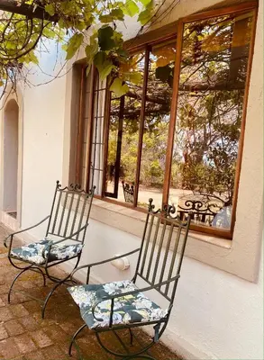 two chairs sitting in front of a window at Wild Fig Guesthouse in White River