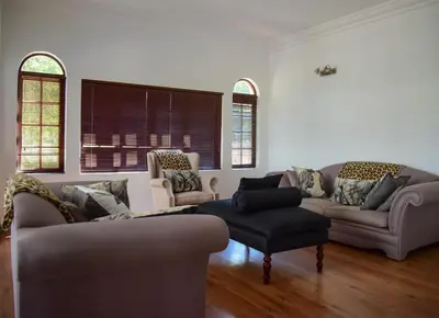 a living room with two couches and a chair at Indlovukazi Guesthouse in Hartbeespoort