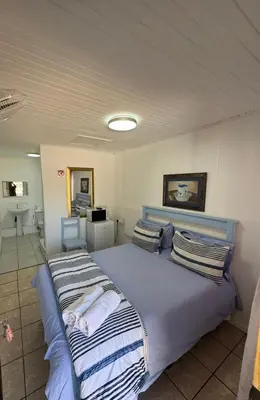 a bedroom with a large bed with striped pillows at CenturionSleep&Go in Centurion