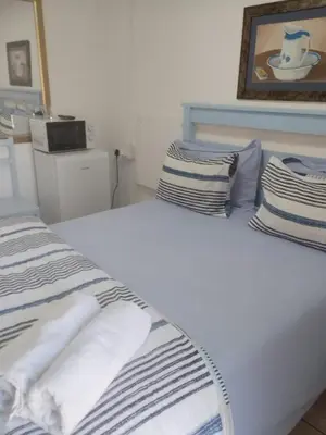 a bedroom with two beds and a picture on the wall at CenturionSleep&Go in Centurion