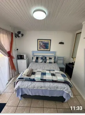 a bedroom with a bed with a blue and white comforter at CenturionSleep&Go in Centurion
