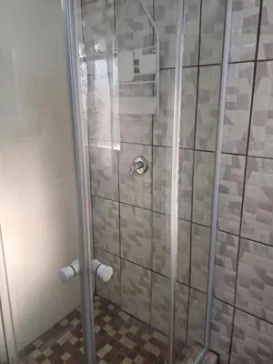 a shower with a glass door in a bathroom at CenturionSleep&Go in Centurion