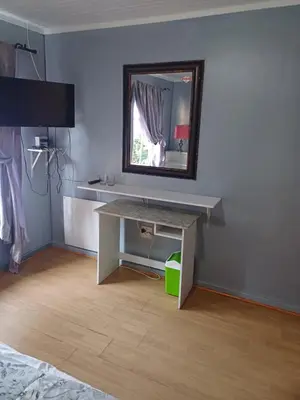 a room with a table and a mirror on a wall at CenturionSleep&Go in Centurion