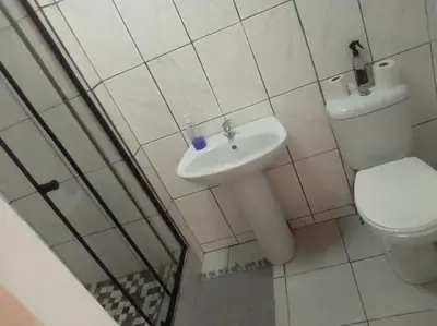 a white bathroom with a toilet and a sink at CenturionSleep&Go in Centurion