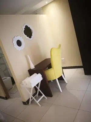 a yellow chair and a desk in a room at Mmakgabo Boutique Lodge in Bela-Bela