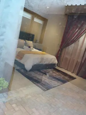 a bedroom with a bed with a red curtain at Mmakgabo Boutique Lodge in Bela-Bela