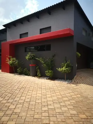 a building with a red stripe on the side of it at Mmakgabo Boutique Lodge in Bela-Bela
