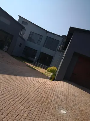 a building with a brick driveway in front of a building at Mmakgabo Boutique Lodge in Bela-Bela