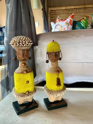 two dolls sitting on a table in a bedroom at Rooibos Luxury Bush Cottage in Hoedspruit
