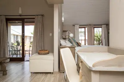 a bedroom with a bed and a view of a porch at Three Thymes Inn in Tierpoort