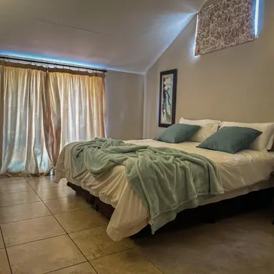 a bedroom with a large bed with green pillows at Three Thymes Inn in Tierpoort