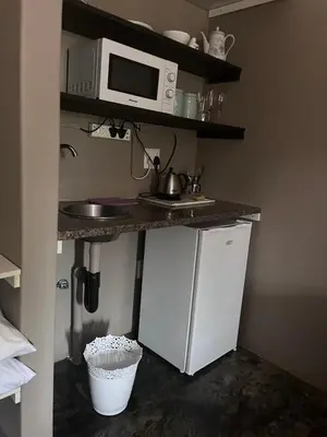 a kitchen with a sink and a microwave on a counter at Three Thymes Inn in Tierpoort
