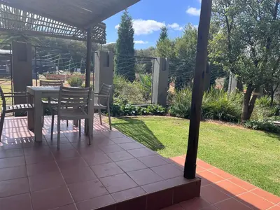 a patio with a table and chairs in a yard at Three Thymes Inn in Tierpoort