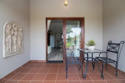 a dining room with a table and chairs on a tile floor at Three Thymes Inn in Tierpoort