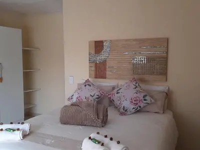 a bedroom with a bed with pillows on it at Aloes Bush Stay in Hoedspruit