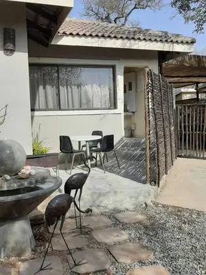 a patio with a table and chairs in front of a house at Aloes Bush Stay in Hoedspruit