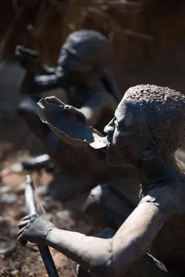 a bronze statue of a boy holding a utensil at African Rock Lodge in Hoedspruit