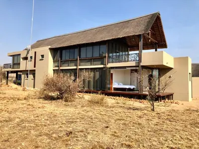 a large house in the middle of a field at Kuwisa Lodge in Bela-Bela