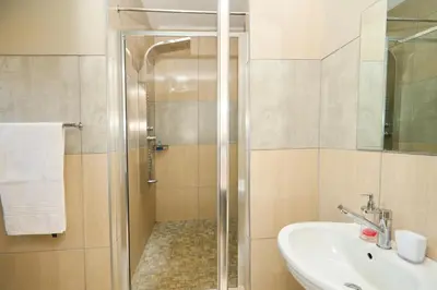 a bathroom with a shower and a sink at Menlyn Maine Spacious Cottage in Pretoria